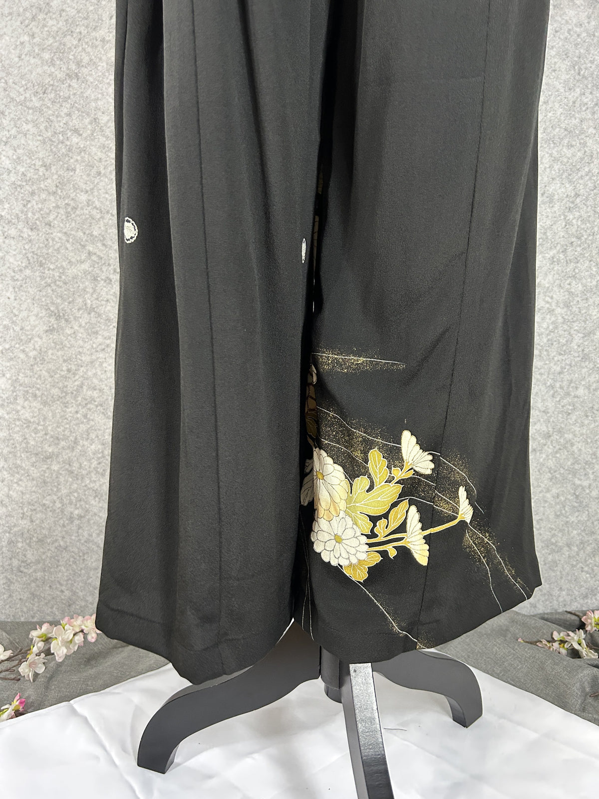 Black upcycled tomesode kimono wide leg pants with white and gold chrysanthemums, back view with family crests