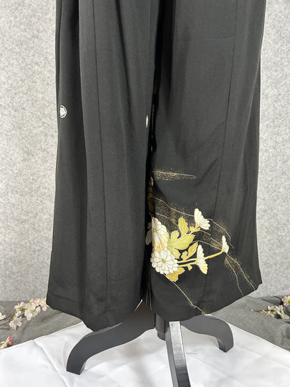Black upcycled tomesode kimono wide leg pants with white and gold chrysanthemums, back view with family crests