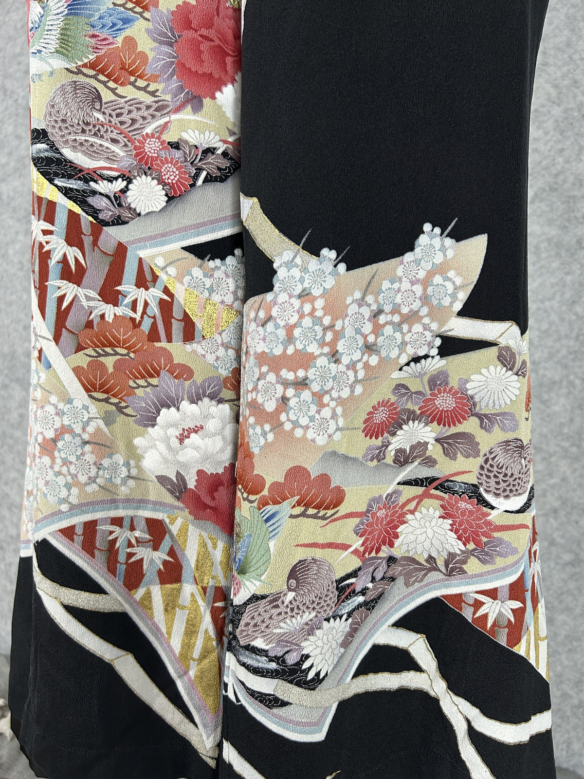 Black upcycled tomesode kimono wide leg pants with mandarin ducks and peonies in fan panels, close-up of the mandarin ducks and plum blossoms