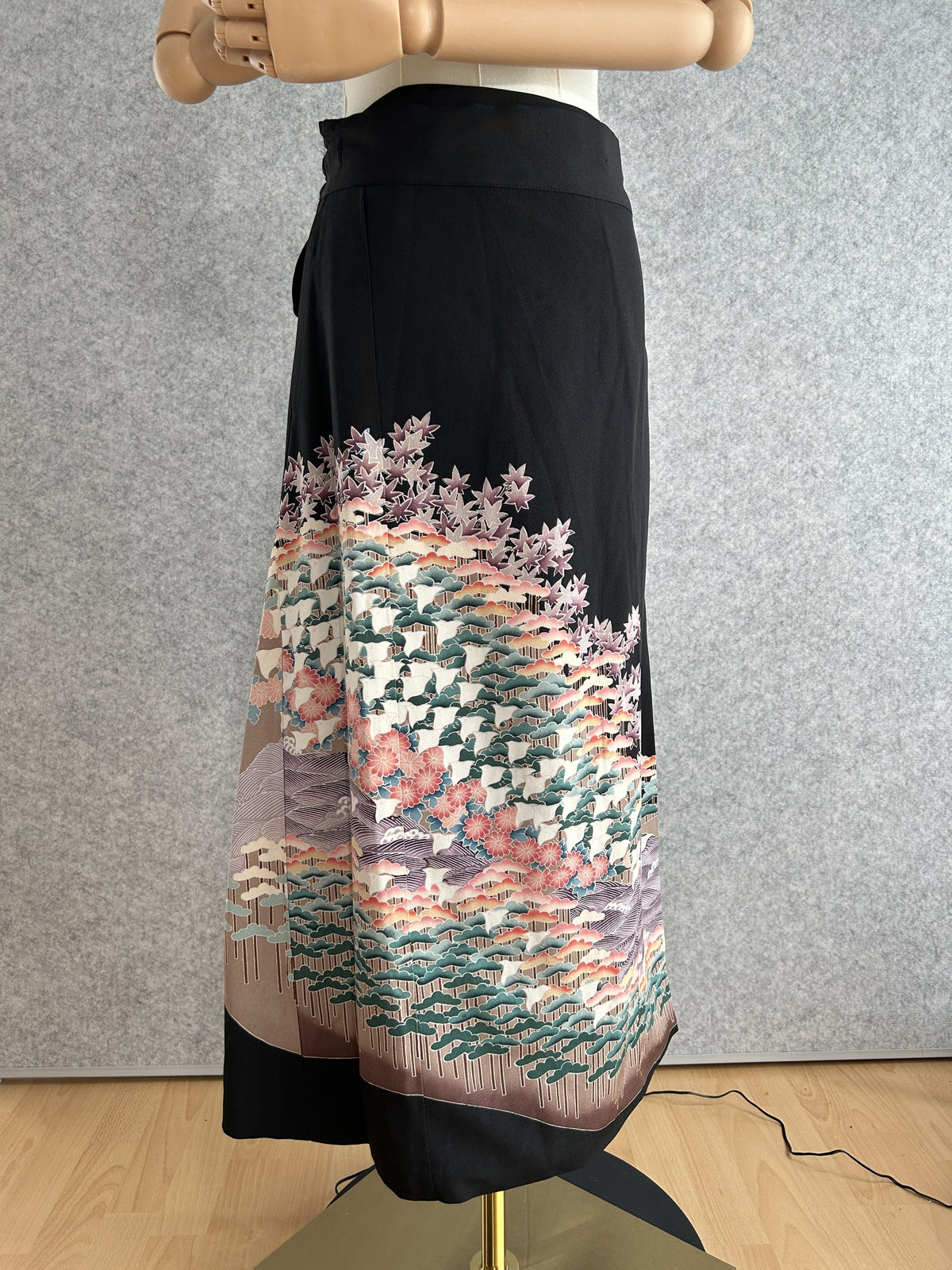 Black kimono wrap skirt with pine tree and maple leaf design at hem, front view