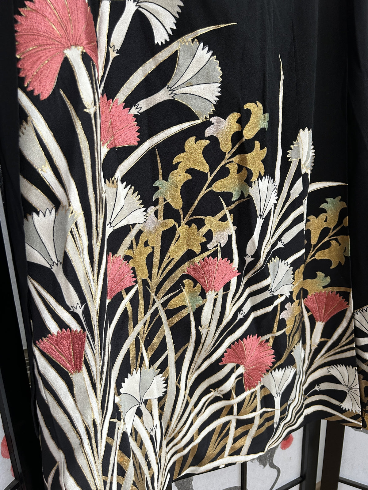 Black kimono wrap skirt, detail of pink and white flowers at hem