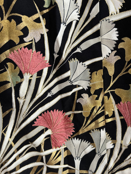 Black kimono wrap skirt, close-up of pink and white fringed flowers