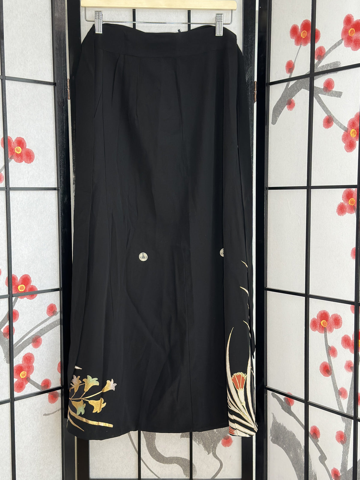 Black kimono wrap skirt, back view with small floral design at hem