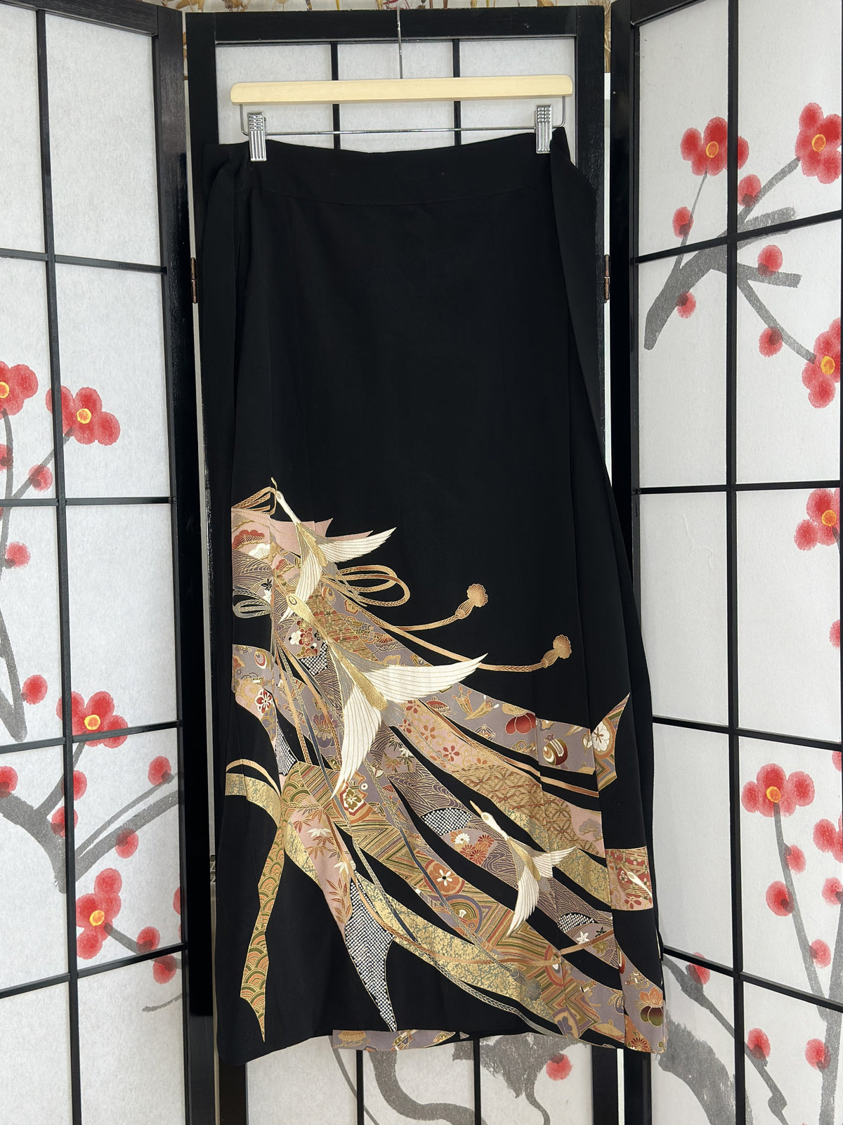 Black kimono wrap skirt with white cranes and gold ribbon design, full view
