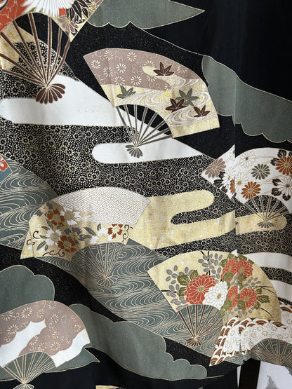 Black kimono wrap skirt, close-up of cream and grey-green folding fans