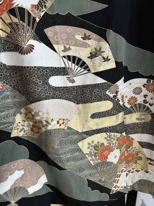 Black kimono wrap skirt, close-up of cream and grey-green folding fans