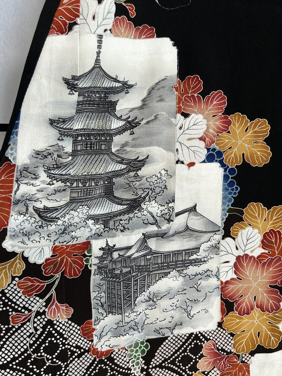 Black kimono wrap skirt, close-up of grey pagoda picture with red leaves