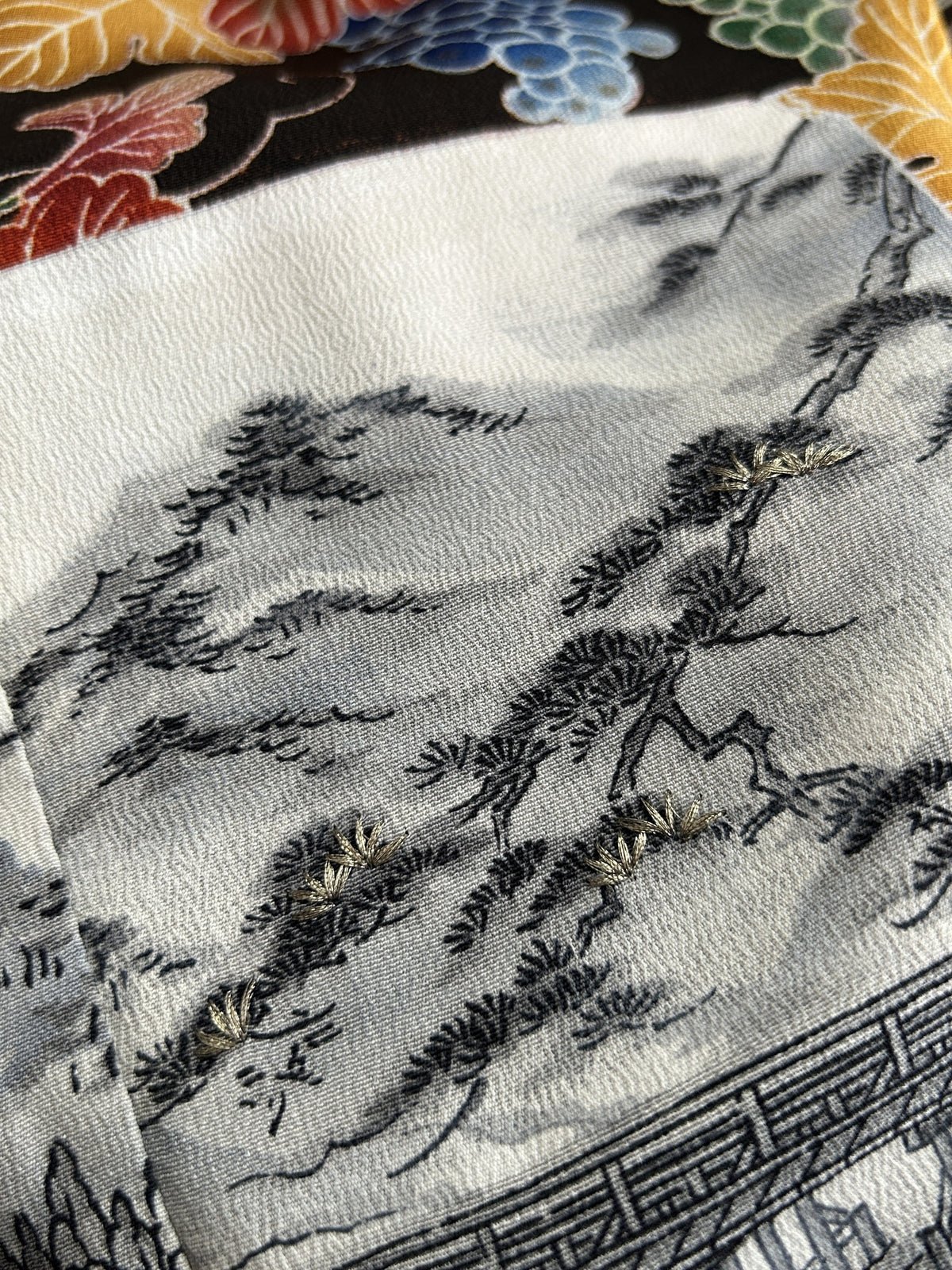 Black kimono wrap skirt, close-up of grey painted pine trees with gold stitching