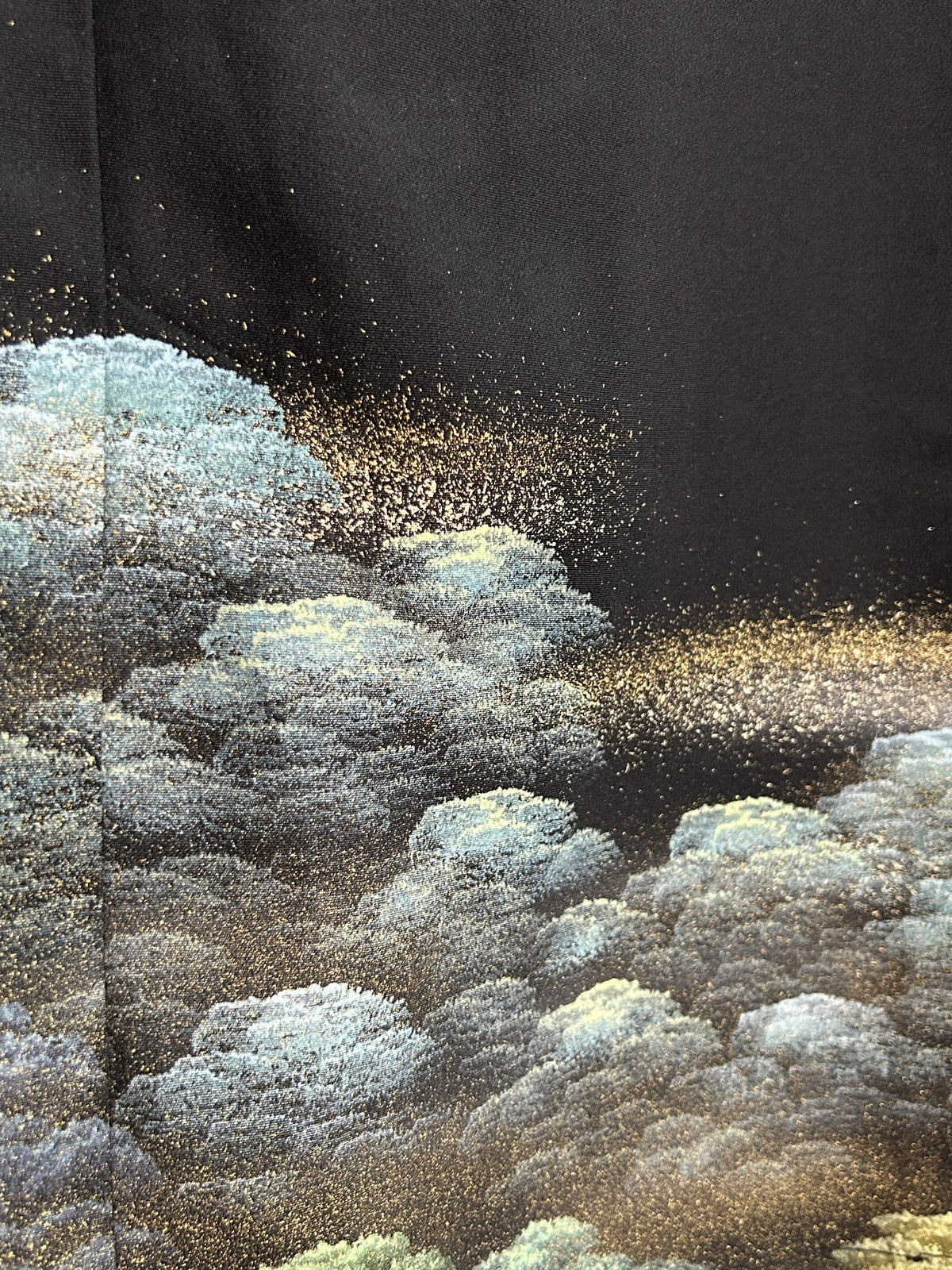 Black kimono wrap skirt, close-up of blue-green treetops with gold speckles