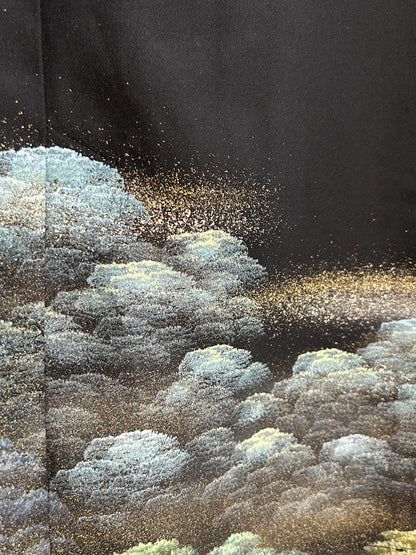 Black kimono wrap skirt, close-up of blue-green treetops with gold speckles