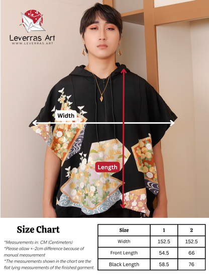 Person wearing a black hoodie with floral designs and size chart on a beige wall background