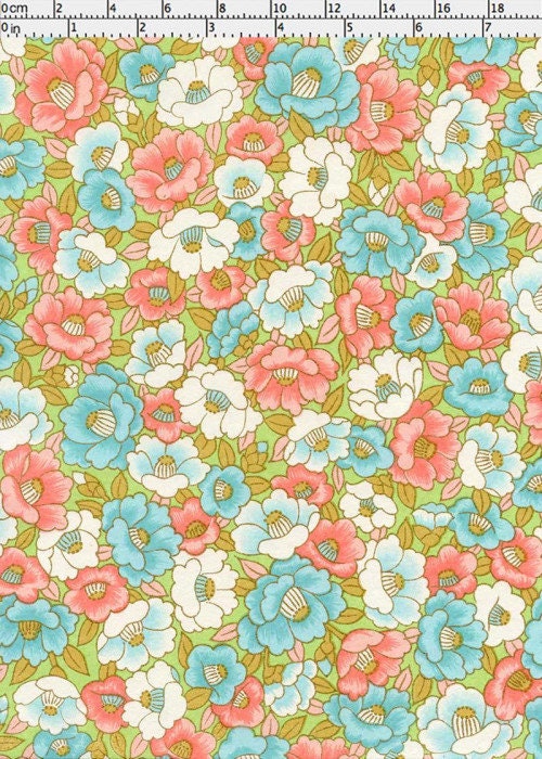 Floral chiyogami paper pattern with pink, blue, and white flowers on a green background with a ruler for scale
