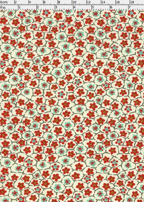 Floral patterned chiyogami paper with red and green flowers on a beige background with a ruler for scale