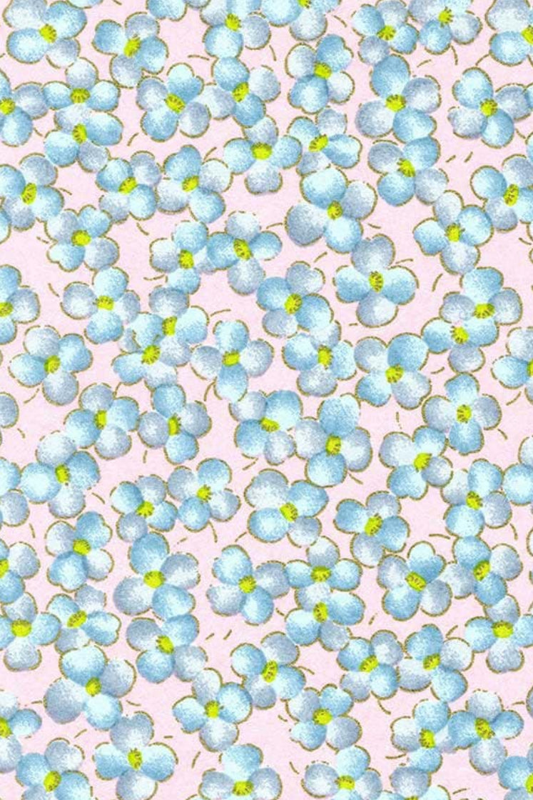 Chiyogami paper with Pattern of small blue flowers with green centers on a pink background