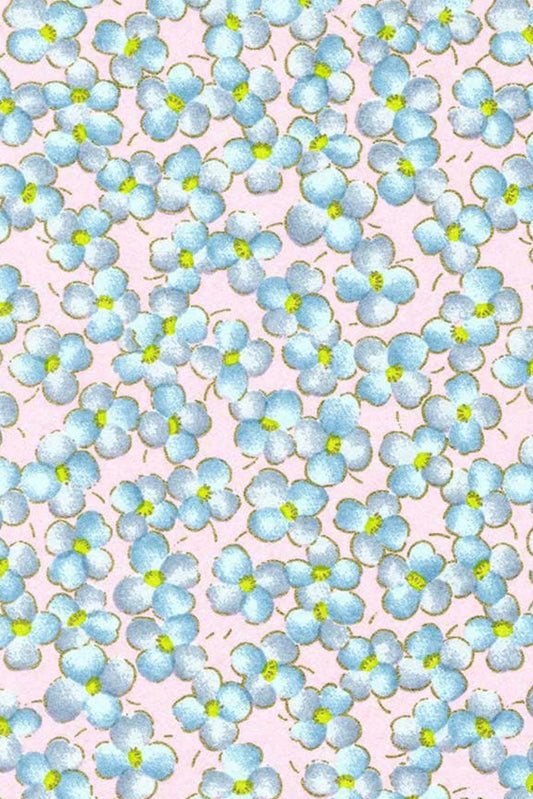 Chiyogami paper with Pattern of small blue flowers with green centers on a pink background