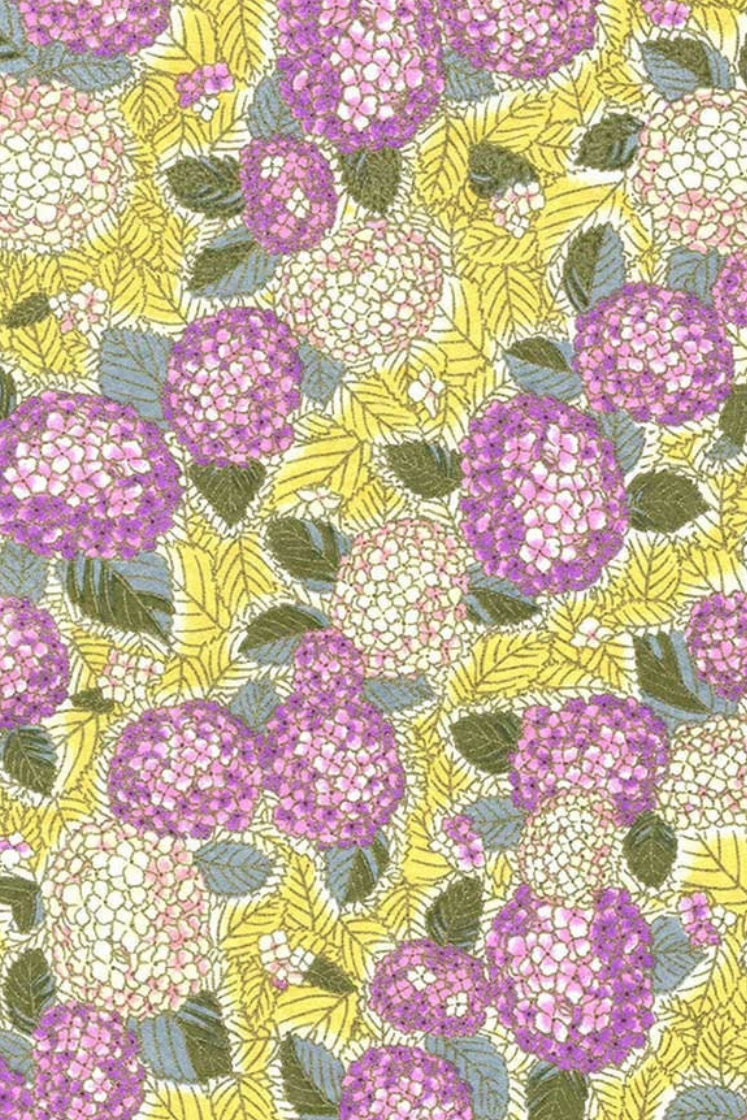 Patterned chiyogami paper with purple and white flowers on a yellow background