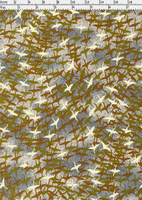 Patterned chiyogami paper with birds and branches on a brown and green background with a ruler for scale