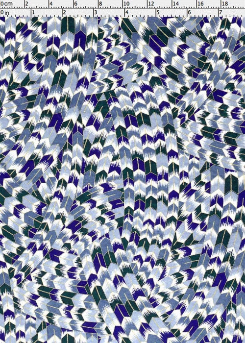 Patterned chiyogami paper with blue and green design on a white background with a ruler for scale