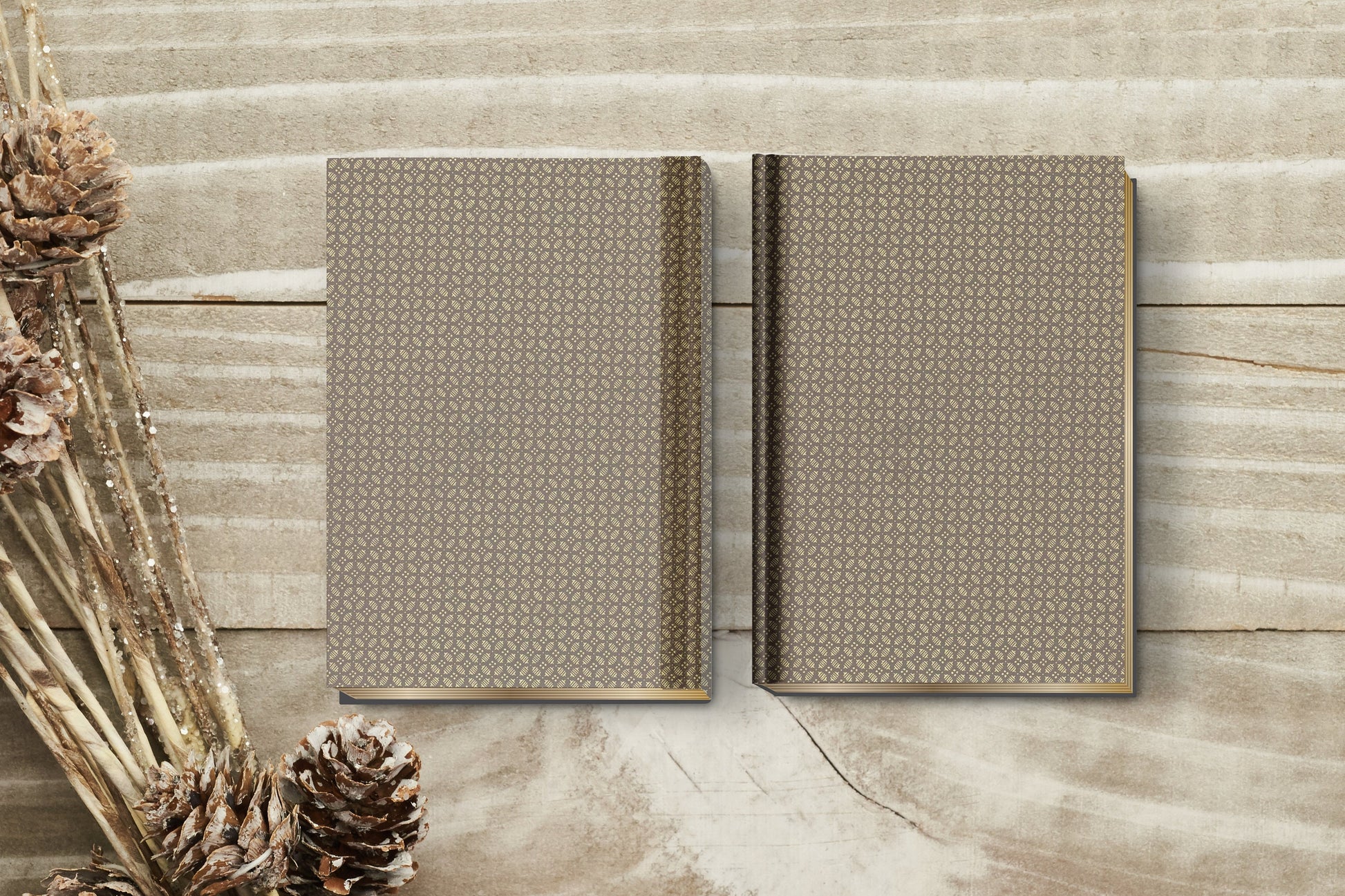 Two patterned books made with chiyogami paper in a bookbinding project on a wooden surface with decorative elements.