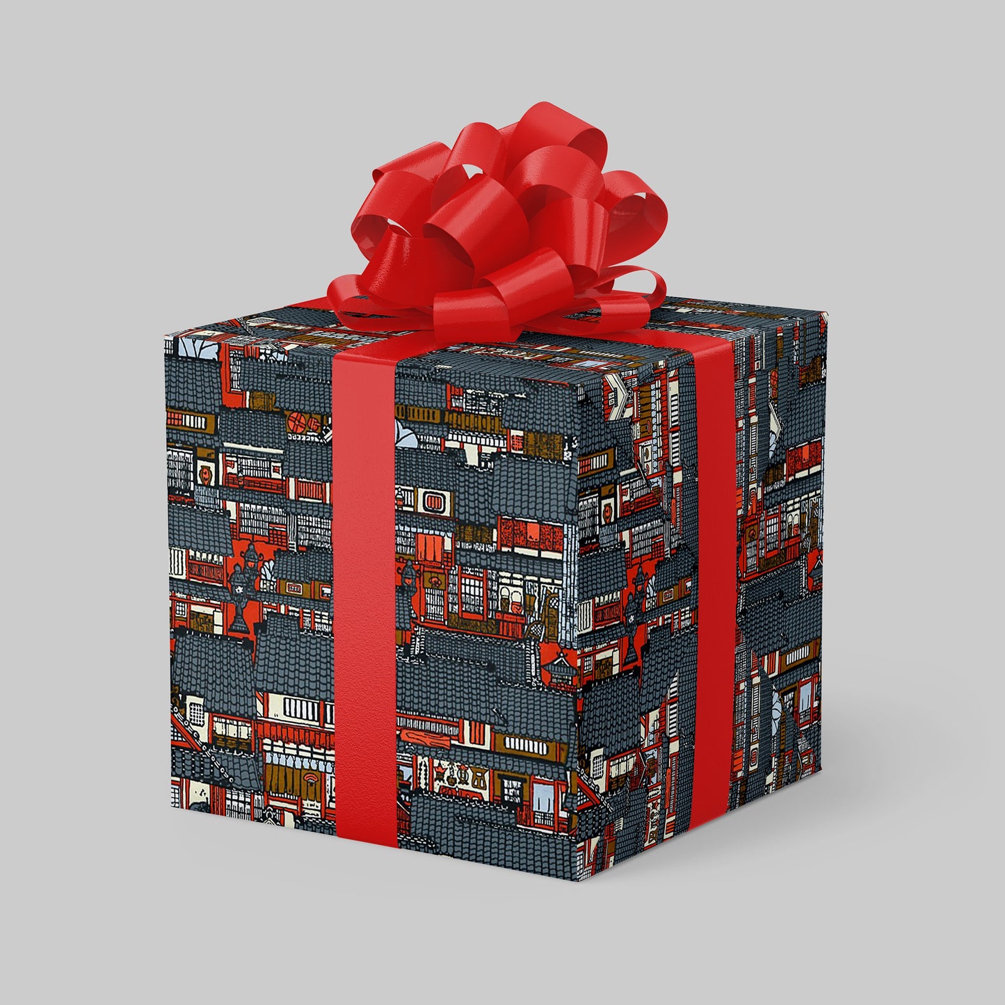 Gift box wrapped with chiyogami paper with a red ribbon on a gray background