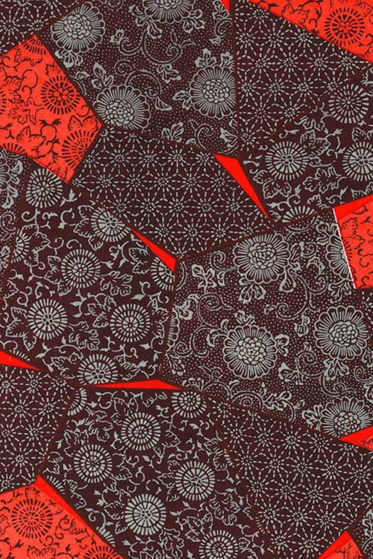 Patterned chiyogami paper with red and black geometric shapes on a dark background