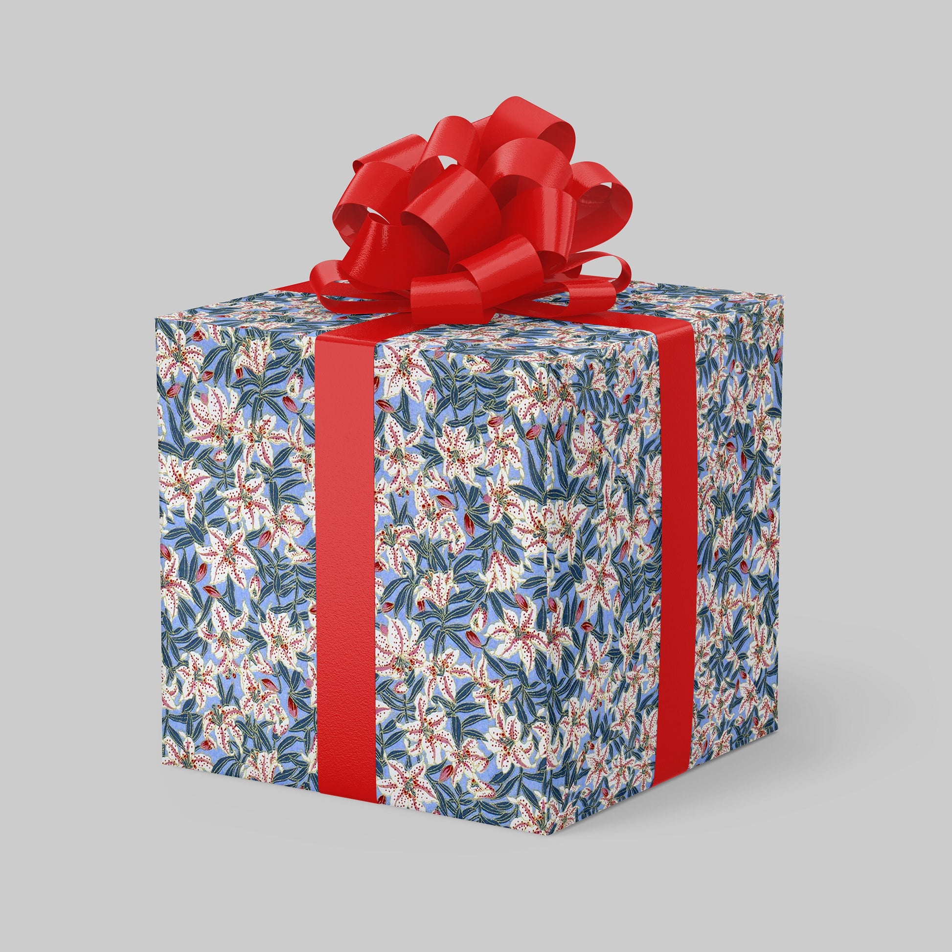 Gift box wrapped with chiyogami paper with floral pattern and red ribbon on a gray background