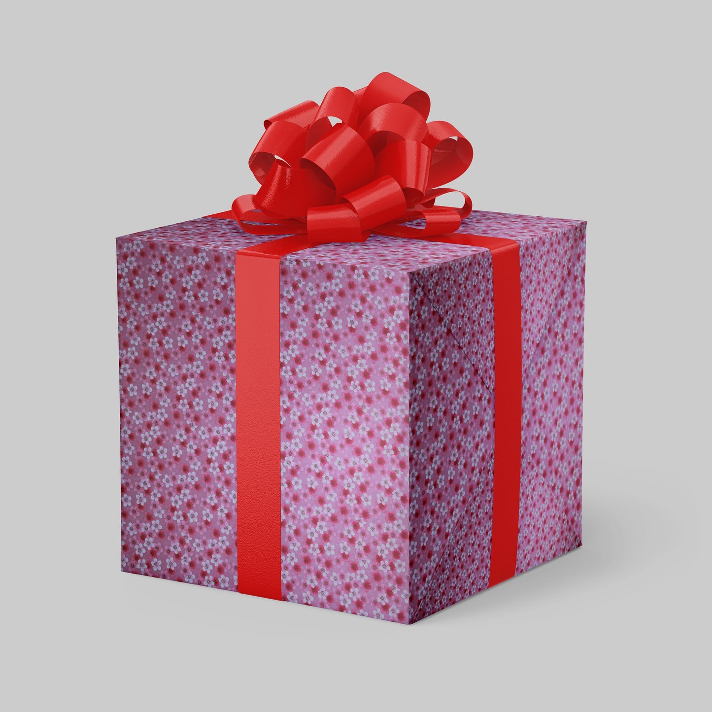 Gift box wrapped with chiyogami paper with floral pattern and red ribbon on a gray background