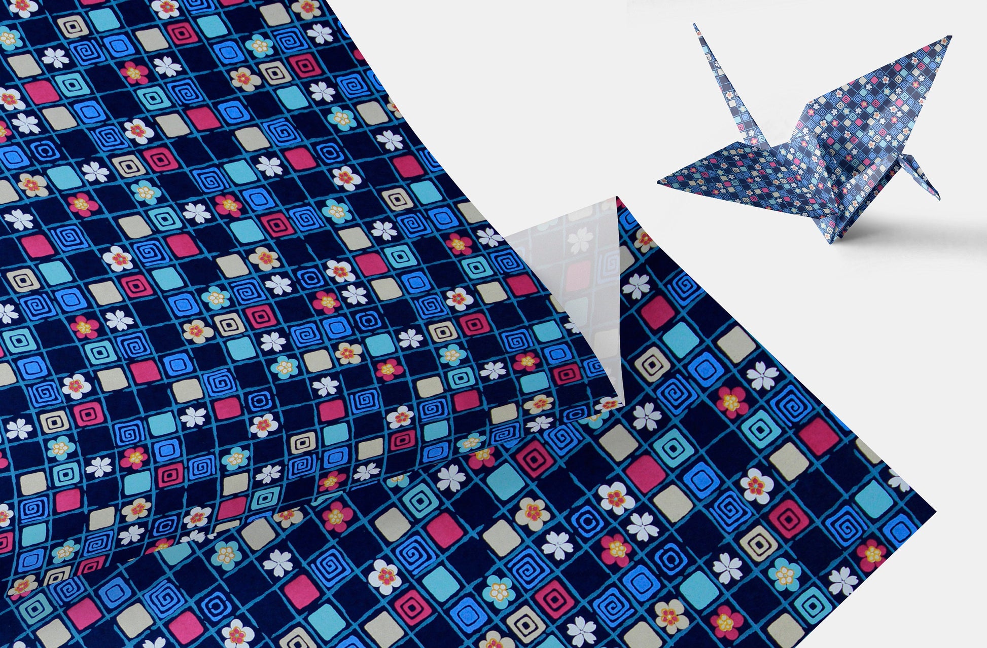 Colorful patterned chiyogami paper with a folded paper crane on a white background