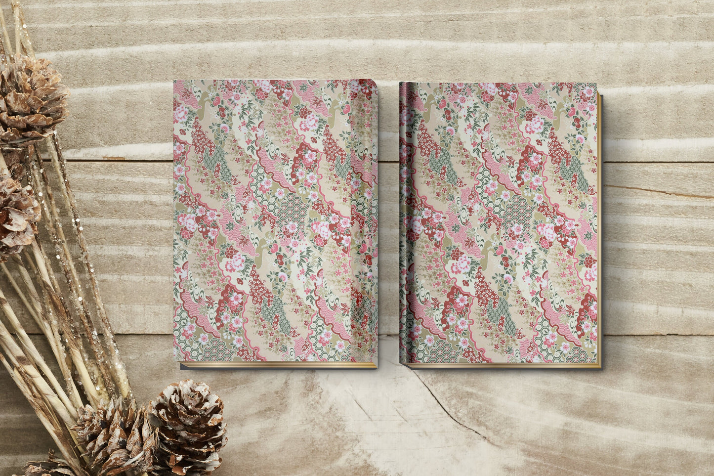 Two floral-patterned books made with chiyogami paper in a bookbinding project on a wooden surface with decorative elements.