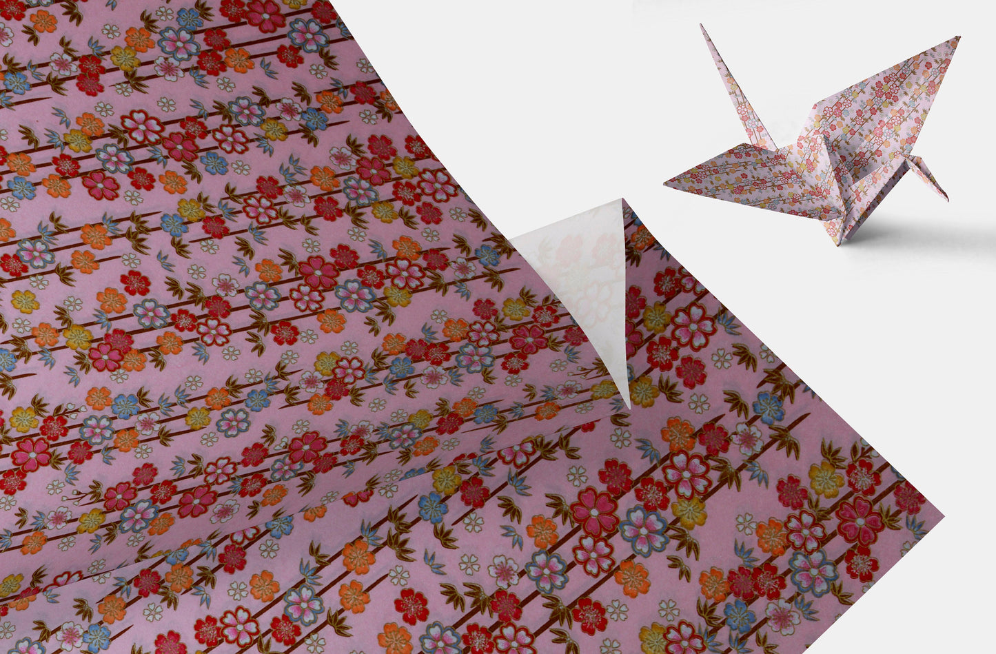 Floral-patterned chiyogami paper with a folded paper crane on a white background