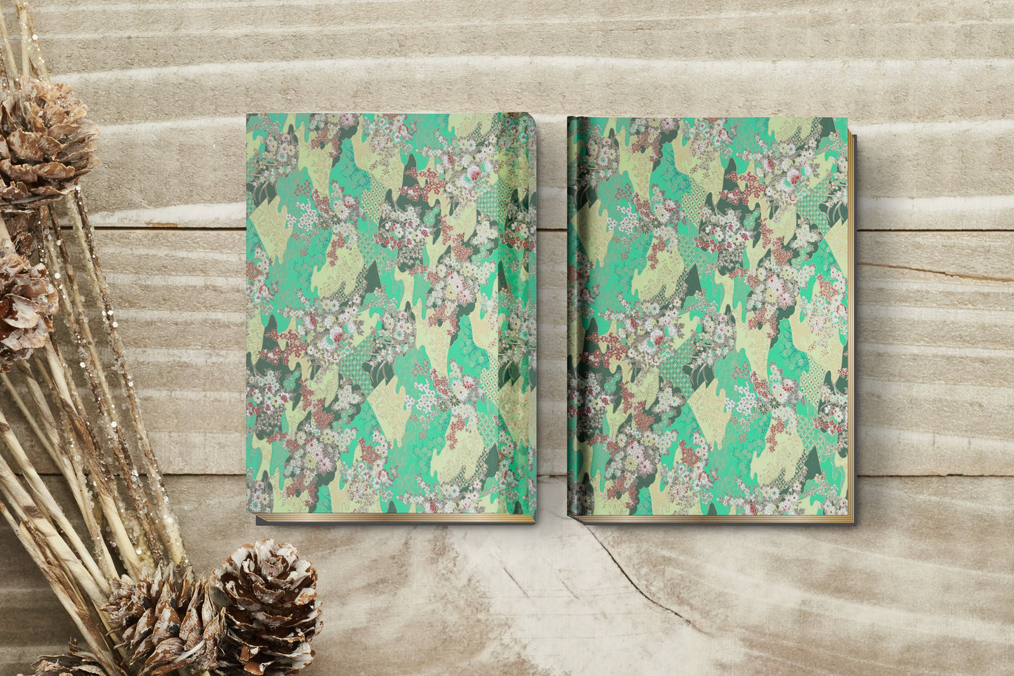 Two chiyogami paper floral-patterned notebooks on a wooden surface with decorative elements.