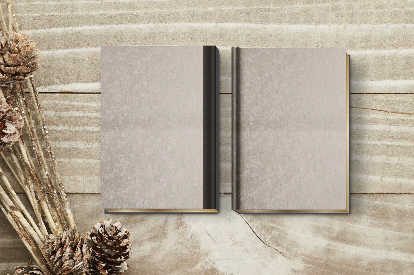 Two gray books made with chiyogami paper in a bookbinding project on a wooden surface with decorative elements