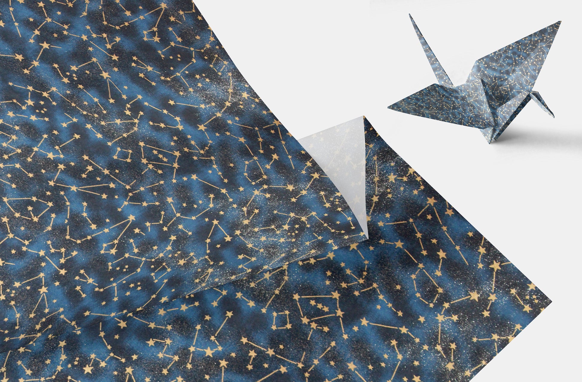 Folding paper with star constellation pattern and a folded paper crane on a white background
