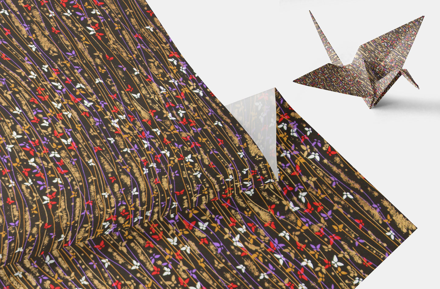 Patterned paper with a folded origami crane on a white background
