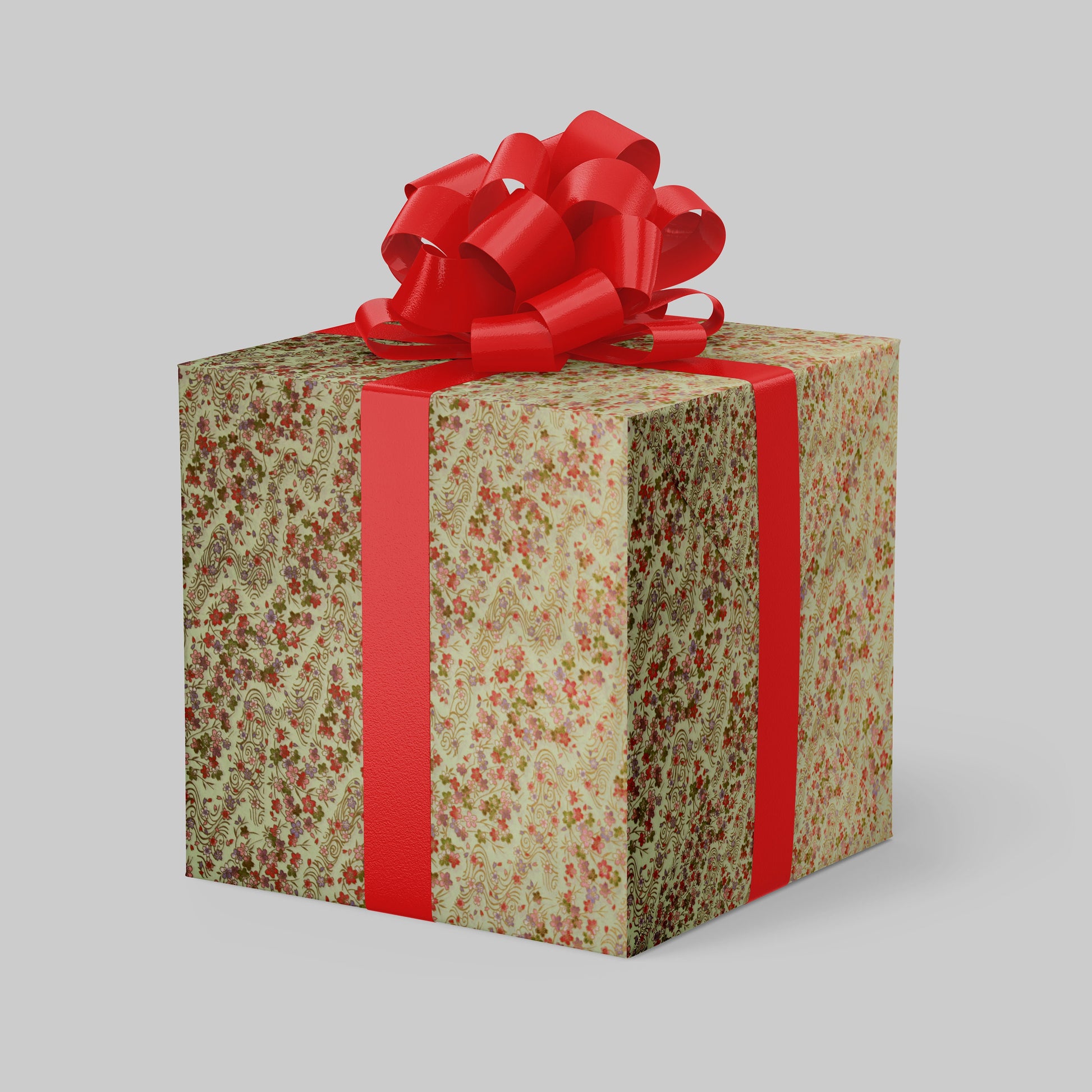 Gift box wrapped with chiyogami paper with floral pattern and red ribbon on a light gray background
