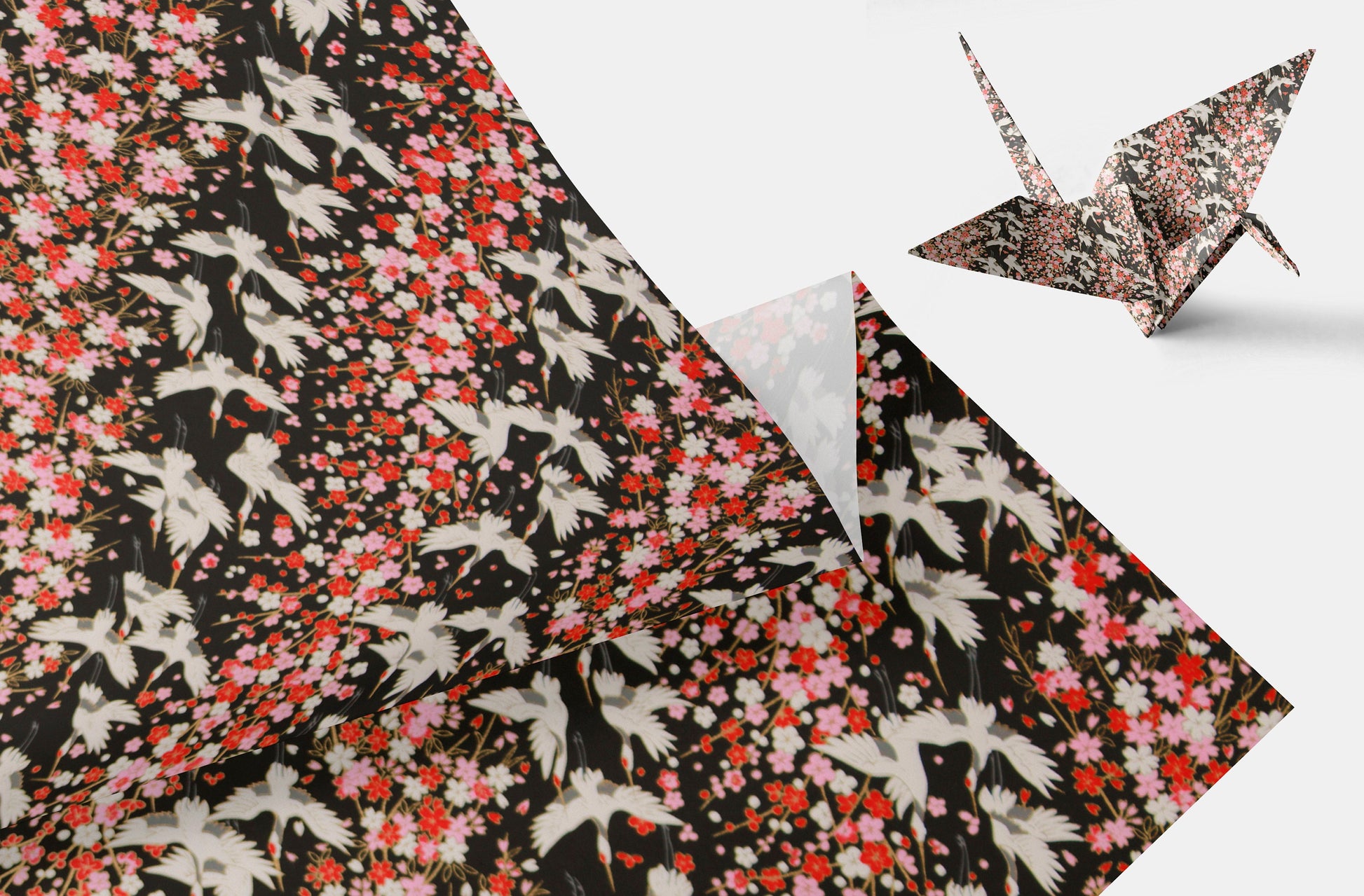 Floral-patterned fabric with a folded corner and an origami crane on a light gray background