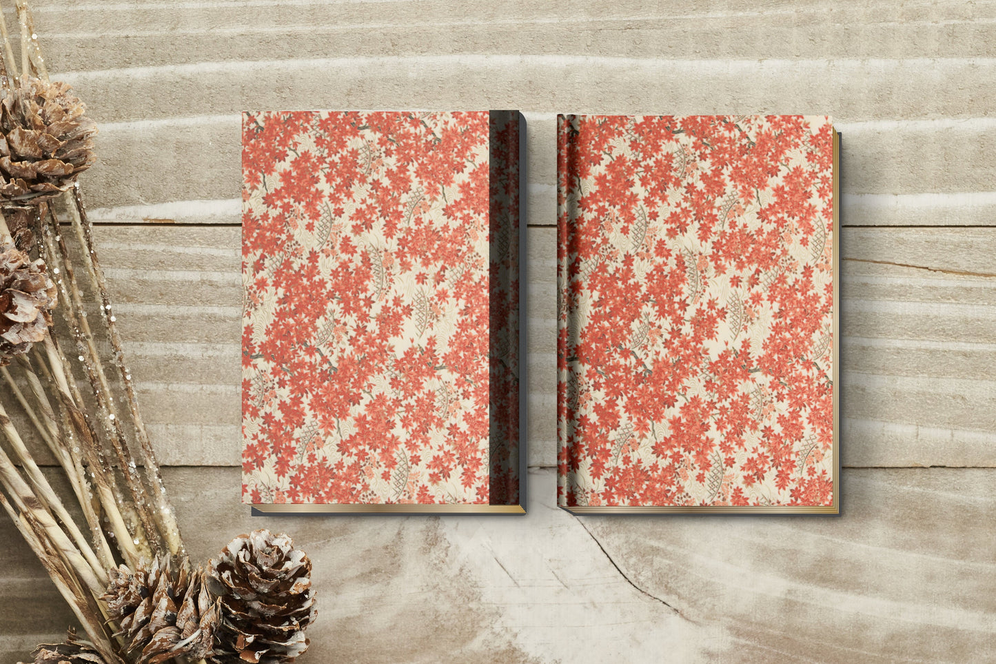 Two floral-patterned notebooks made with chiyogami paper as bookbinding project on a wooden surface with decorative elements.