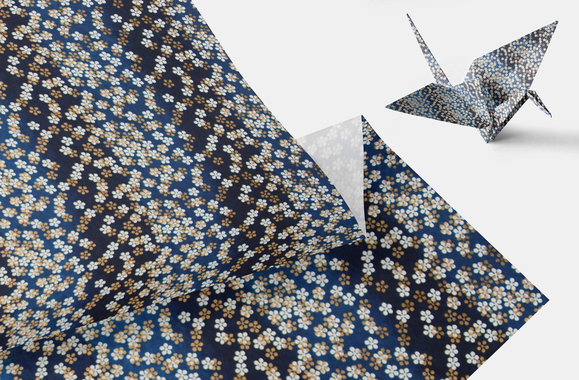 Floral-patterned paper with a folded origami crane on a white background