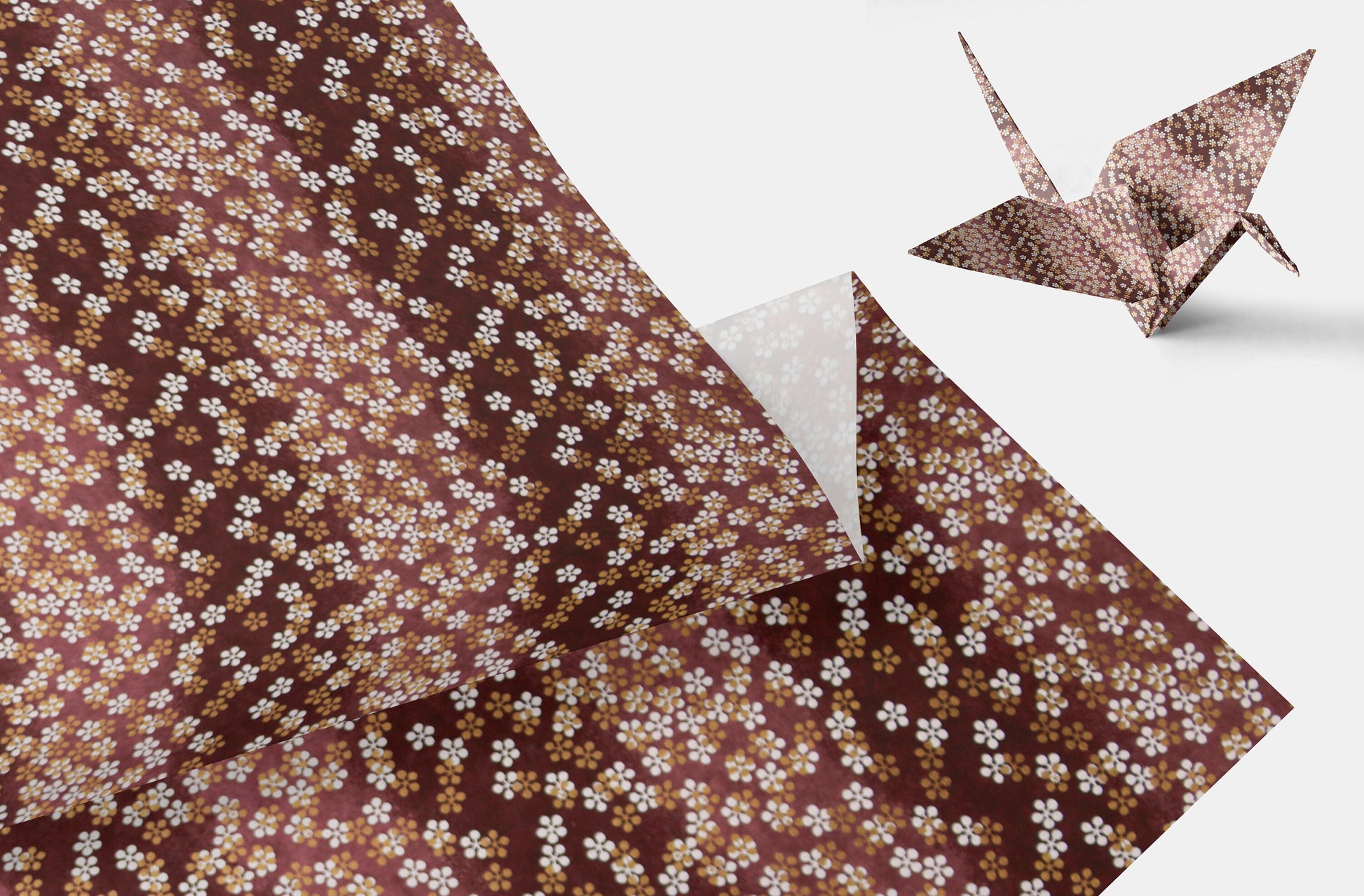 Brown floral-patterned chiyogami paper with a folded paper crane on a white background