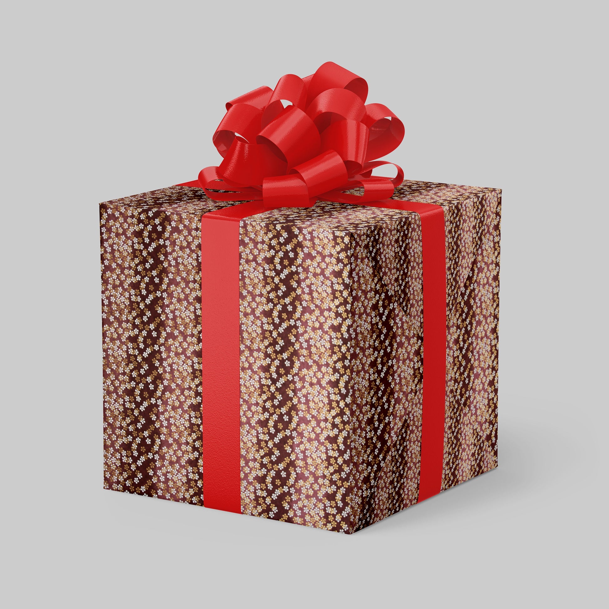 Gift box wrapped with chiyogami paper with brown pattern and red ribbon on a gray background
