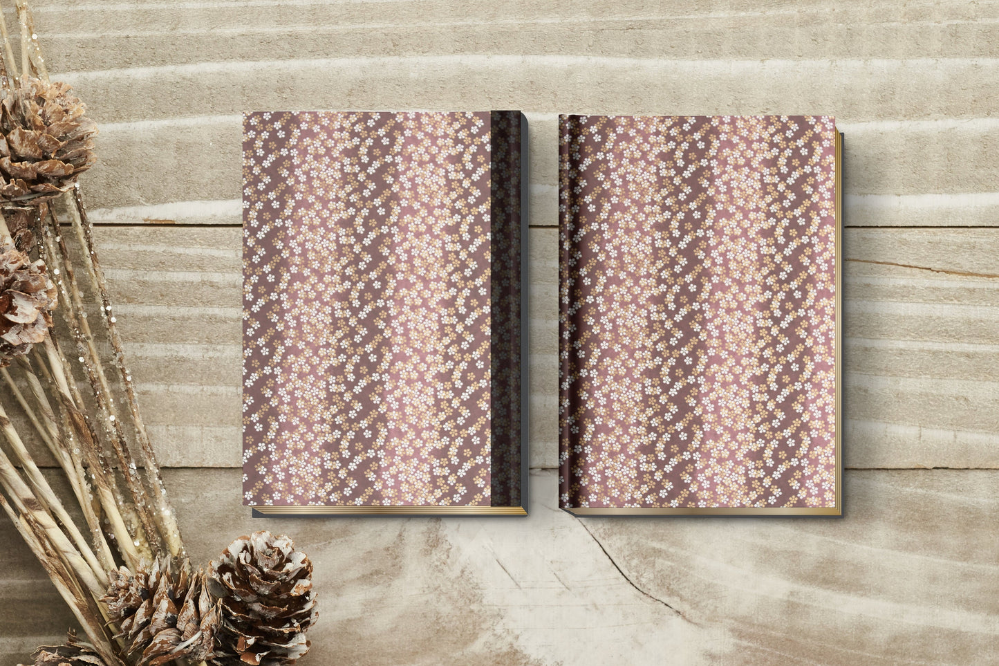Two patterned books made with chiyogami paper in a bookbinding project on a wooden surface with decorative elements.