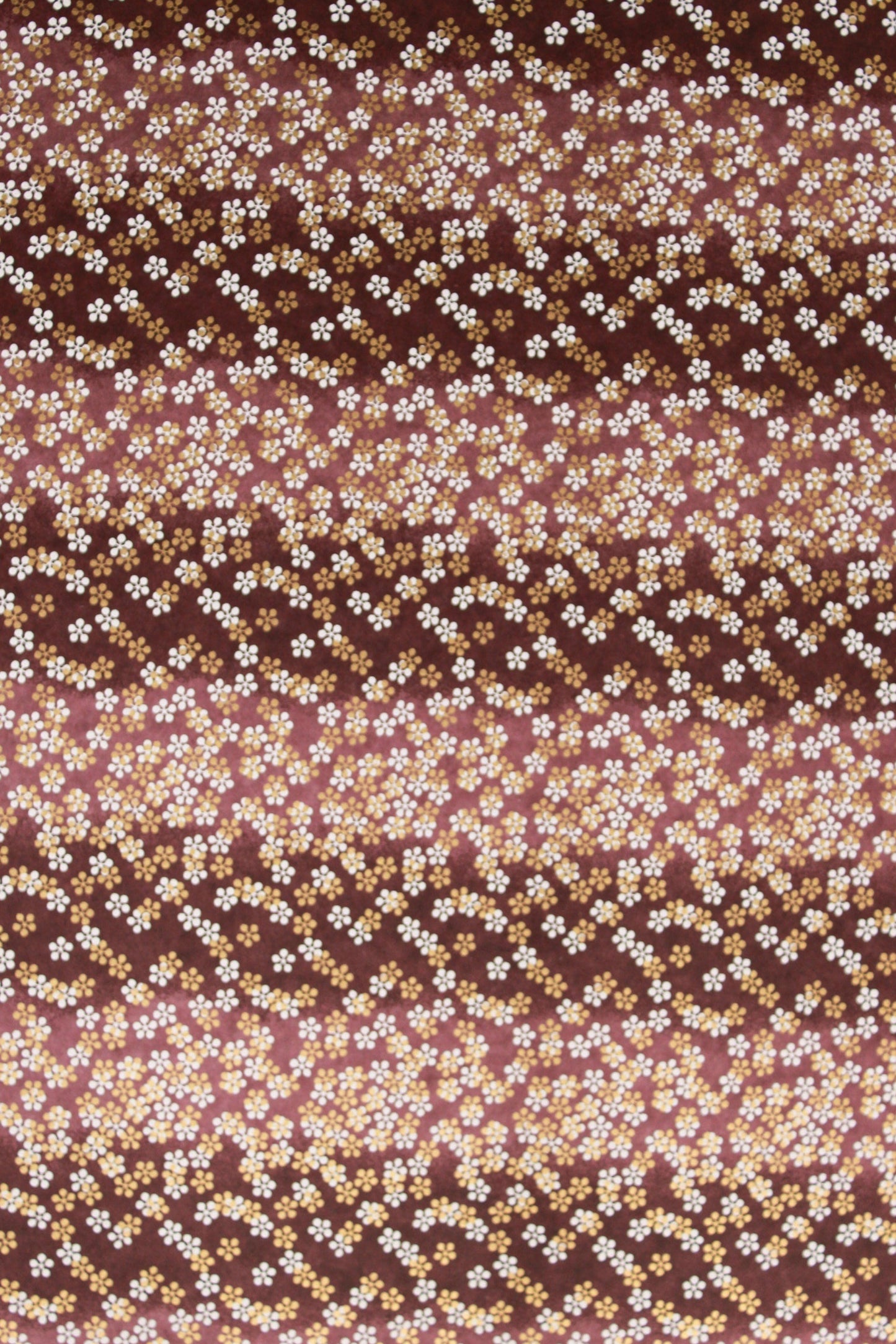 Chiyogami paper with pattern with small white flowers on a brown background