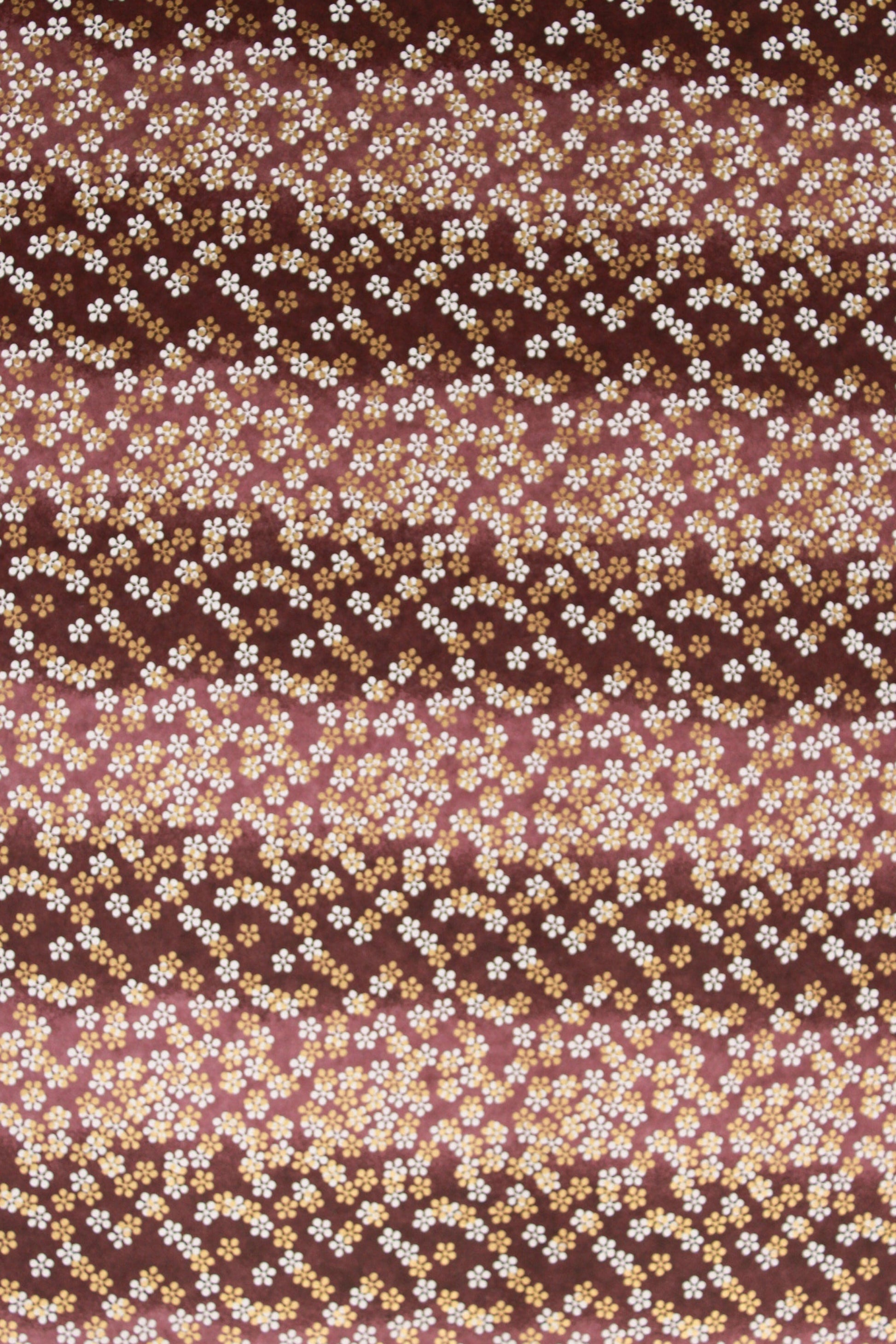 Chiyogami paper with pattern with small white flowers on a brown background