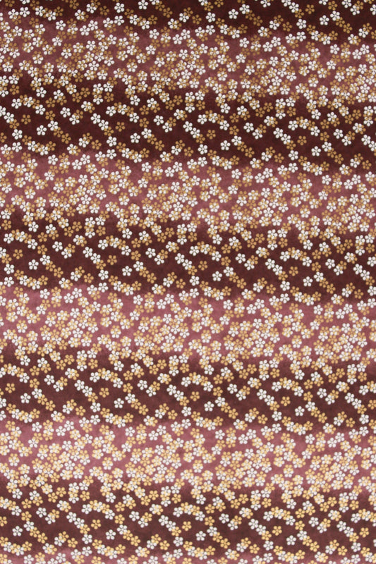 Chiyogami paper with pattern with small white flowers on a brown background