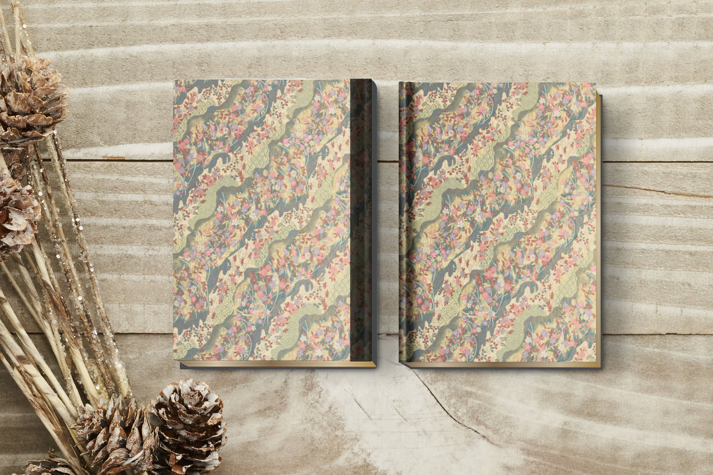 Two decorative books with floral patterns on a wooden surface.