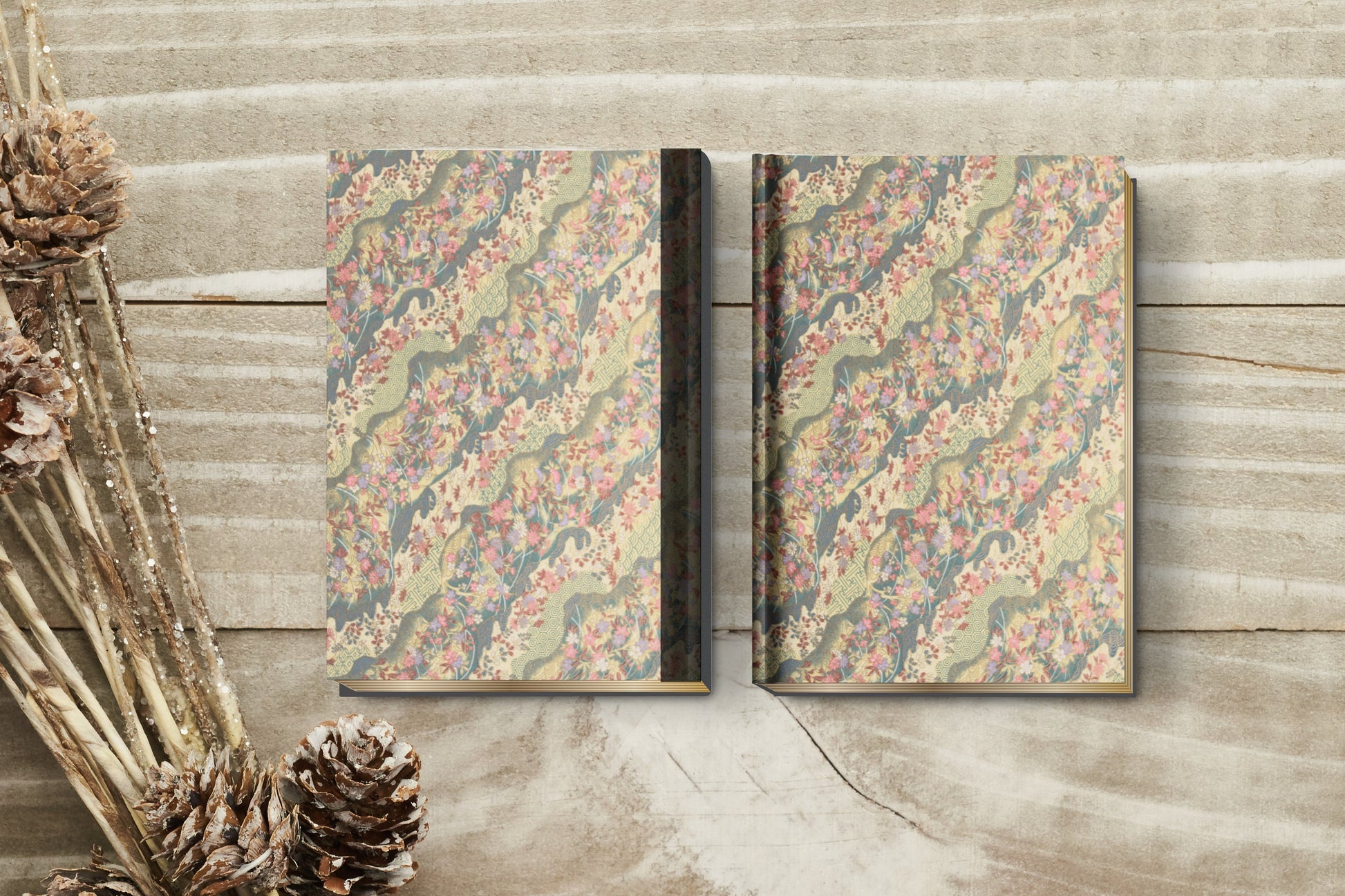 Two decorative books with floral patterns on a wooden surface.