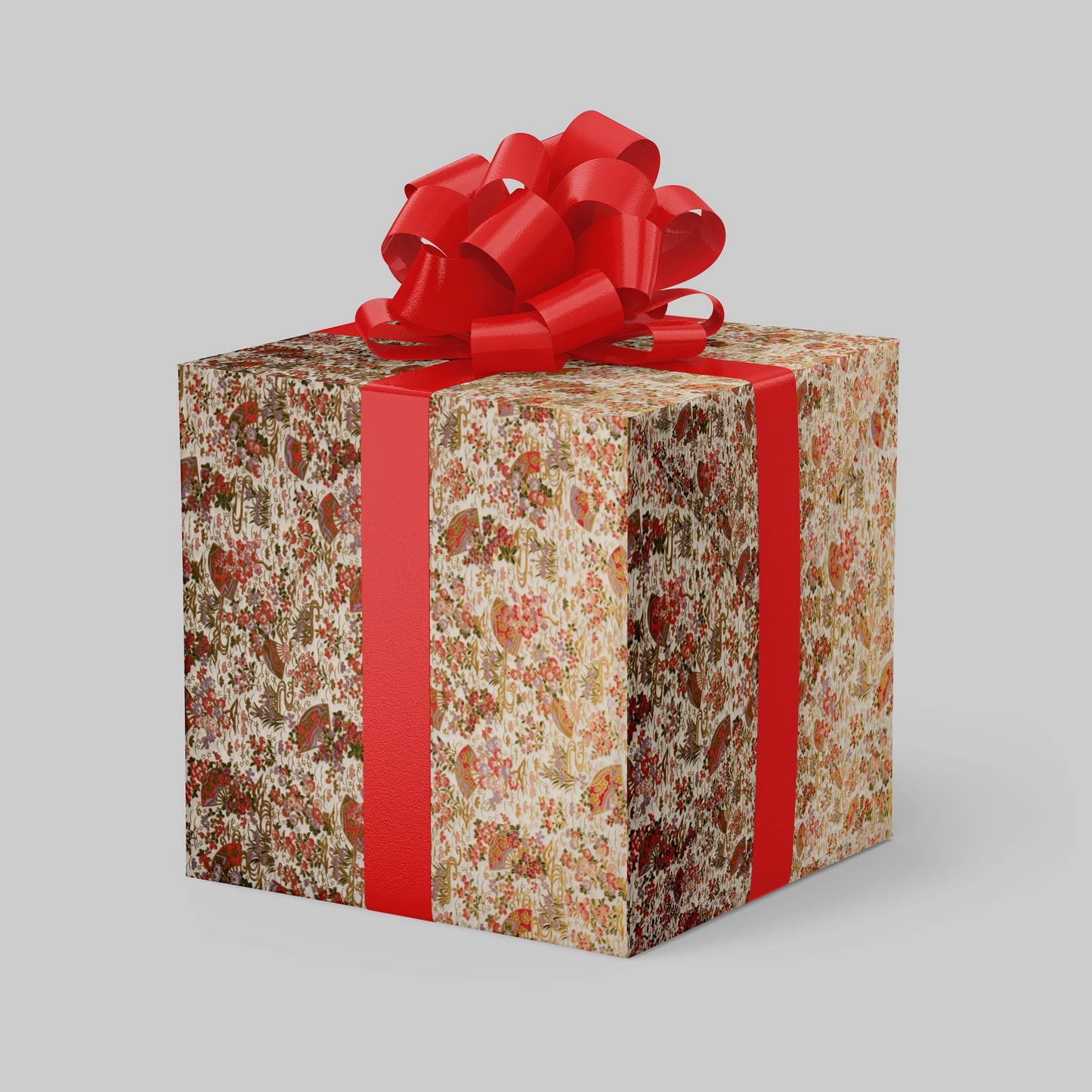 Gift box wrapped with chiyogami paper with floral pattern and red ribbon on a gray background