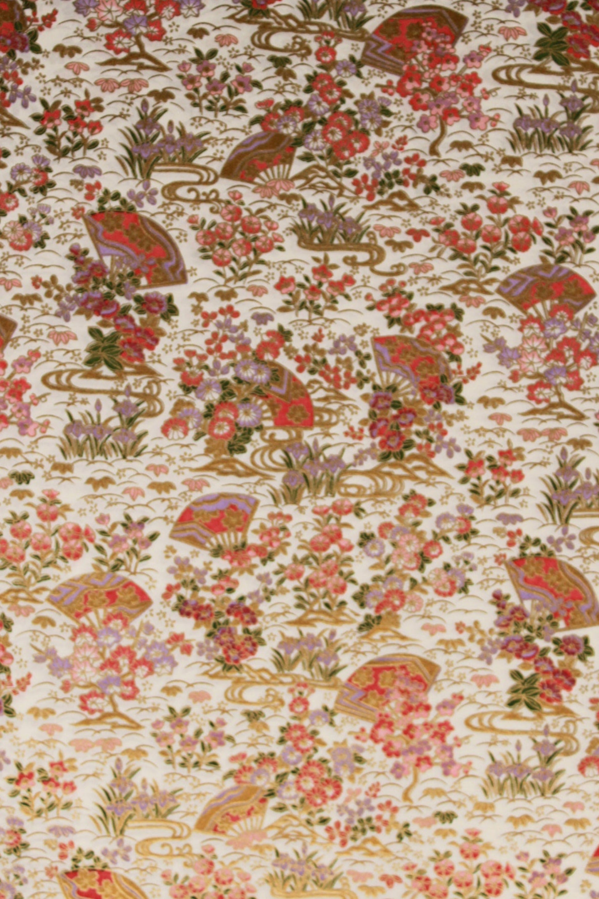 Floral and leaf patterned chiyogami paper with red, green, and brown colors on a beige background.