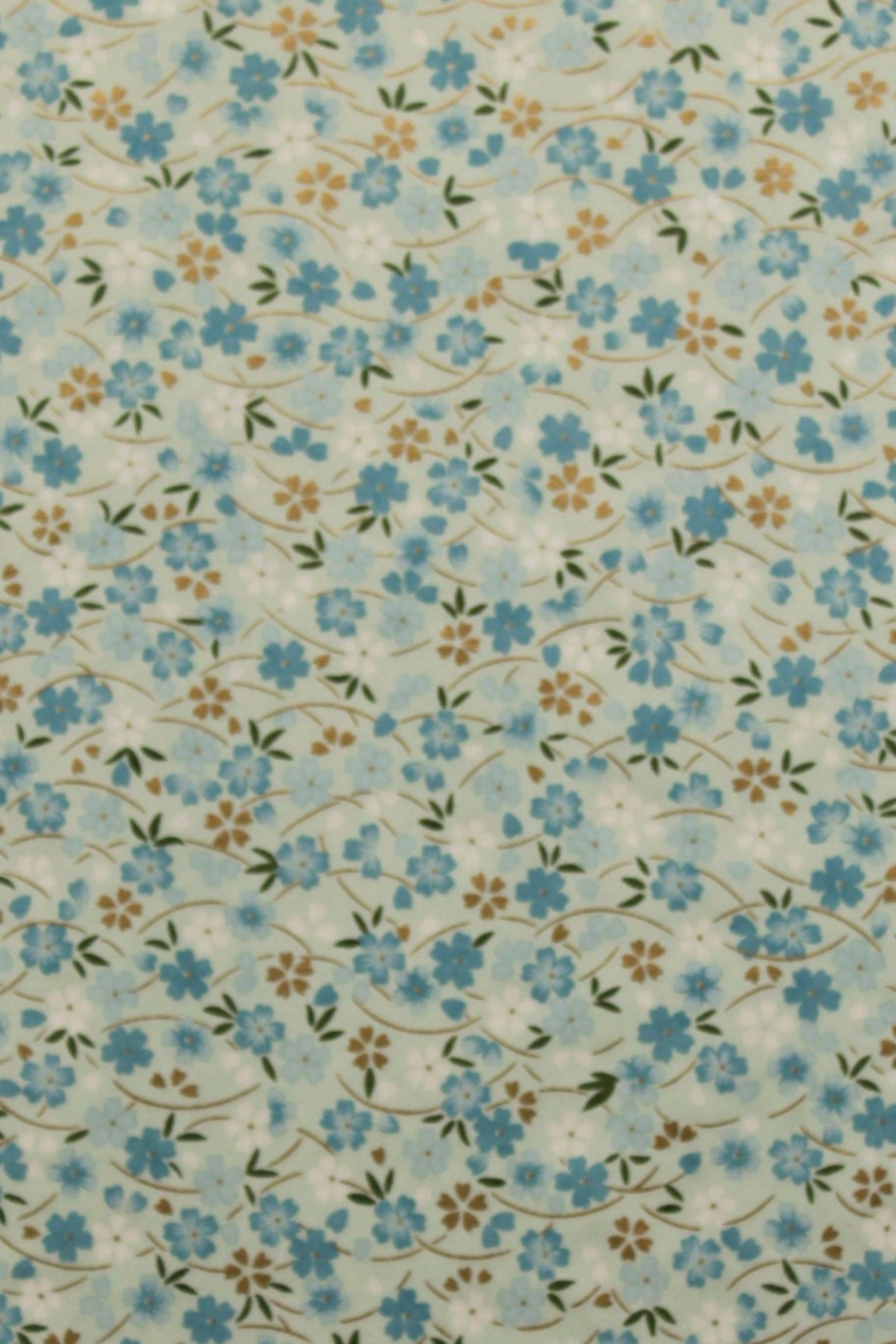 Floral patterned chiyogami paper with small blue flowers on a beige background