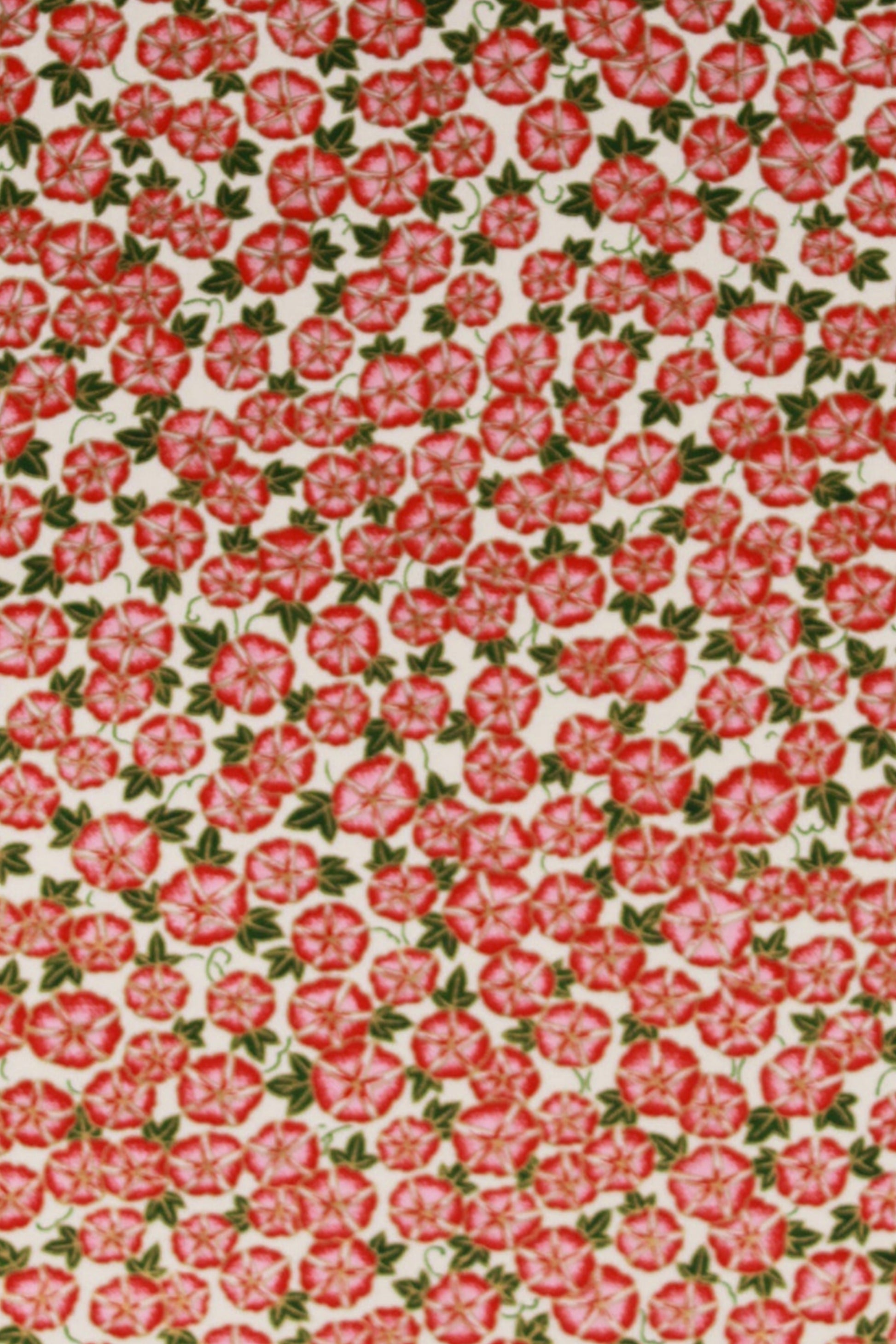 Patterned chiyogami paper with red floral design on a pink background